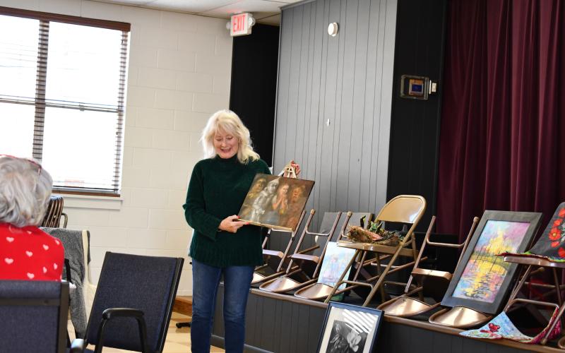 Megan Horn/The Clayton Tribune. Guild member Teresa Weiser showcased a colorful painting of a scarecrow, Tin Man, Dorothy and Cowardly Lion from the movie “The Wizard of Oz.”