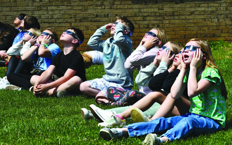 Enoch Autry/The Clayton Tribune. Marylane Dickey (from right), Jones Couey, Raelynn Gordon and Wren Free from Sarah Munroe’s Rabun County Elementary School third grade look at the solar eclipse Monday. Left: Hudson Hamby sees the Eclipse in the sky Monday.