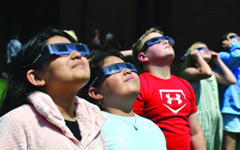 Enoch Autry/The Clayton Tribune. Fourth graders Geraldine Arredondo, Christina Sanchez and Colton Ramey view skyward. Left: Hudson Hamby sees the Eclipse in the sky Monday.