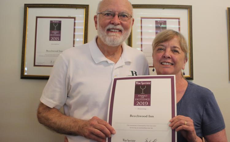 Megan Broome/The Clayton Tribune. David Darugh, left, and Gayle Darugh, hold up their award for having Beechwood Inn honored for its wine program with the Wine Spectator Restaurant Award of Excellence for 2019. They have been a consecutive winner of the award since 2007. 