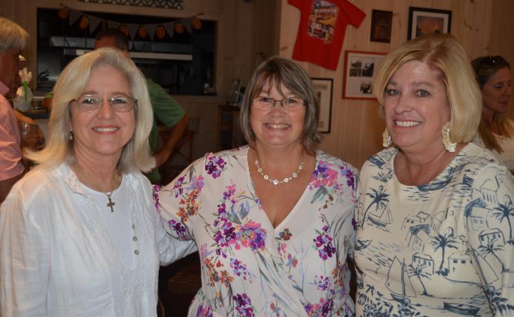 Wayne Knuckles/The Clayton Tribune. Tourism Development Authority Executive Director Teka Earnhardt, center, is greeted by Daphne Lisenby of Wolffork Valley Farms (left) and TDA board vice-chairman Laura Gurley at a reception Tuesday at Clayton Café. 