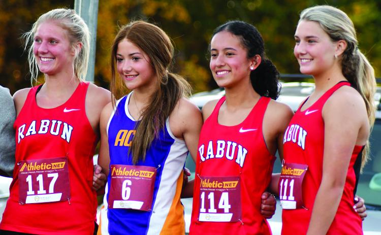 Enoch Autry/The Clayton Tribune. Rabun County Lady Cats cross country runners Molly Jo Wright, Itzia Vasquez and Trea Blalock stand on the individuals’ podium with Athens Christian’s Josi Vaughn for finishing in the top 10 at the region meet.