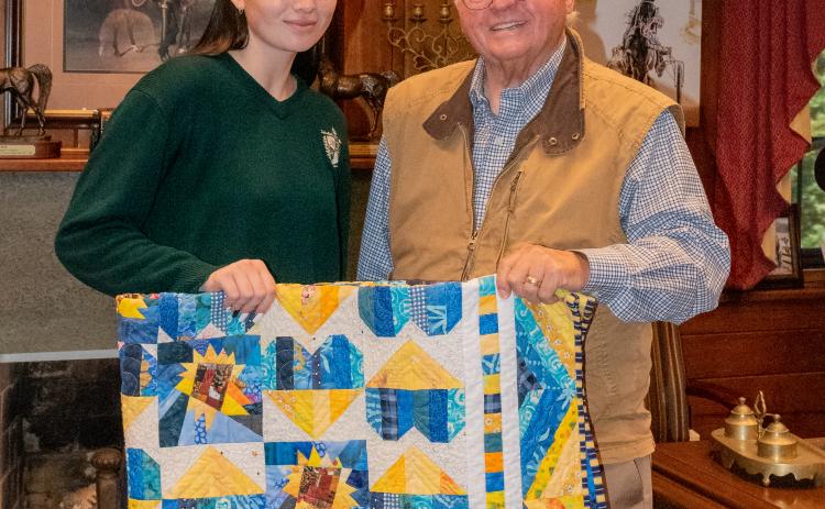 E. Lane Gresham/Tallulah Falls School. Ninel Tarasova receives a quilt featuring the colors of the Ukrainian flag from Tallulah Falls President and Head of School Larry A. Peevy. 