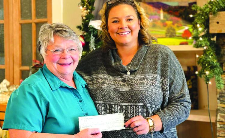 Submitted photo. Bonnie Edmonds with Clayton Cafe (left) presents a donation check to Ara Joyce, outreach and fundraising with Rabun Paws 4 Life.