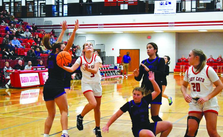 Luke Morey/The Clayton Tribune. With junior Ellie Southards looking on, senior Trea Blalock hits a layup against Walhalla on Friday, Dec. 16. A consistent starter for the Lady Cats, Blalock scored nine points and seven boards on the night. 