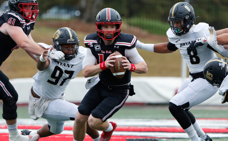 Courtesy of Gardner-Webb Athletics. Gardner-Webb redshirt senior Bailey Fisher evades two tackles in a game against Bryant on Oct. 29. Fisher, a former Rabun County Wildcat, threw for five touchdowns that day in the middle of his campaign to win Big South “Offensive Player of the Year.” 