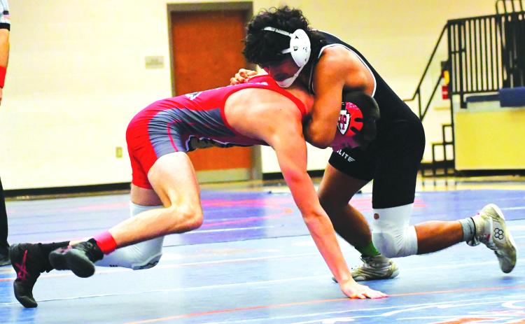 Luke Morey/The Clayton Tribune. Rodolfo Ramos gets a chokehold on Tucker Kinsey from Stephens County in the placement match during the Raider Invitiational on Saturday, Dec. 10. Ramos won his weight class after defeating Kinsey.