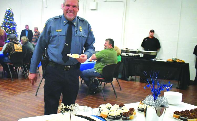 Megan Broome/The Clayton Tribune. Mountain City Police Chief Tom Garrison is all smiles as he cuts his cake at his retirement reception from the City of Mountain City on Dec. 30, 2022. Garrison retires after serving as a law enforcement officer for 28 years and Mountain City Police Chief for 18 years.