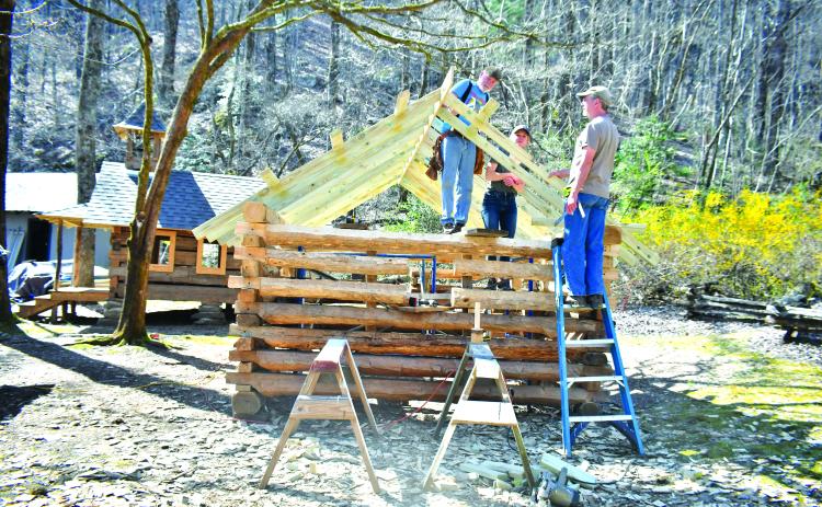 Megan Broome/The Clayton Tribune. Volunteer Tommy Thompson; Kami Ahrens, curator and director of education for Foxfire; and Barry Stiles, museum director, work to build the Ingram Mule Barn as the newest addition to the Children’s Village at the Foxfire Museum and Heritage Center. The scaled-down village for kids, modeled after existing buildings, is being built by hand using traditional tools like those used over 100 years ago. 