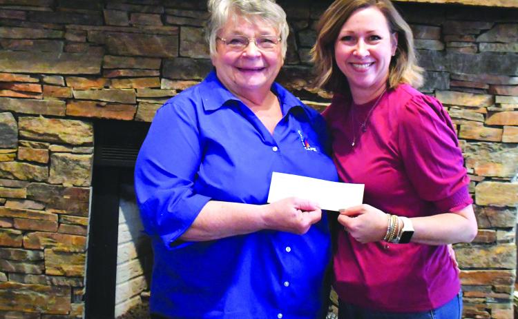 Megan Broome/The Clayton Tribune. Bonnie Edmonds, owner/operator of Clayton Cafe & Market, presents a donation check to Elizabeth Adams, executive director for Place of Hope North Georgia, following the Spaghetti Dinner Raise a Fork for Great Causes event Feb. 20 that raised $4,542 for the local nonprofit Place of Hope North Georgia. 