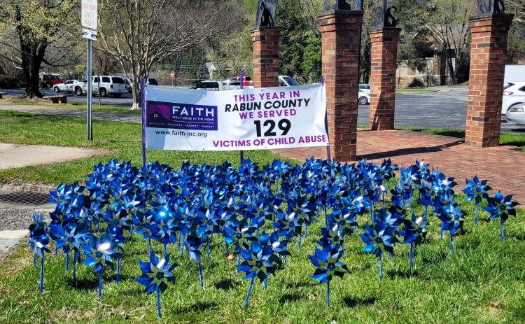 Megan Broome/The Clayton Tribune. Pinwheels on display in front of the Rabun County Courthouse represent 129 victims of child abuse who were served in Rabun County this year. Pinwheels are also on display at Rabun County Division of Family and Children Services. 