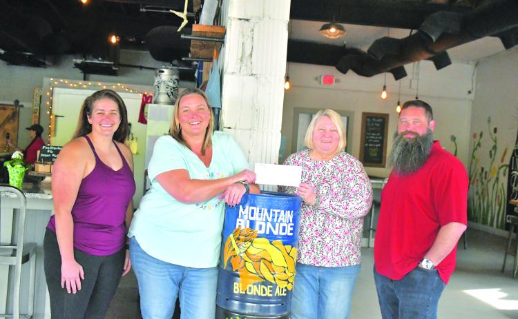 Megan Broome/The Clayton Tribune. Nancy Gribble with Ferst Readers of Rabun County accepts a donation check for $3,075 from nonprofit night held at Currahee Brewing Company on April 6. Pictured are Ara Joyce, Hillary Marshall, Gribble and Scott Mazarky. 