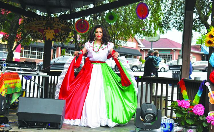 Megan Broome/The Clayton Tribune. Restaurant goers look on as Veronica Trejo, la leyenda hecha voz, performs traditional Mariachi style music at Universal Joint in Clayton to celebrate Cinco de Mayo Friday, May 5. While in traditional dress, Trejo sang and danced and interacted with the crowd as she celebrated the night away on the outdoor stage.