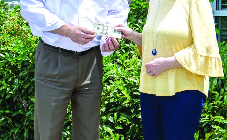 Photo courtesy Kimberly Brown. Cornelia resident Donna Shirley receives her $100 prize money from Alan NeSmith, Community Newspapers Inc. chairman. Shirley’s photograph of the double waterfalls at Anna Ruby Falls graces the cover of the 2023 summer edition of The Mountain Traveler magazine.