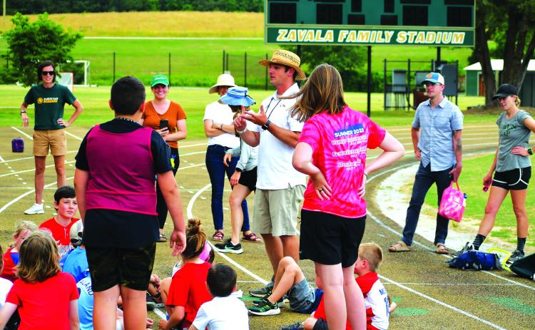 Luke Morey/The Clayton Tribune. Boys lacrosse head coach Ryne Linsley talks to the campers after the Olympics events on Friday, June 16.