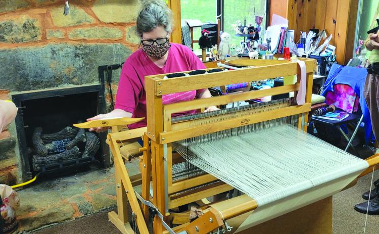 File photo/Megan Broome/The Clayton Tribune. Foxfire’s Kelly Coldren, fiber artist, demonstrates weaving at the Foxfire Museum in 2022. 