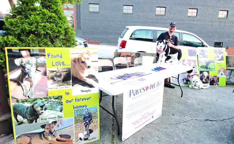 Megan Broome/The Clayton Tribune.  Everett Lampros, public relations, volunteer and adoption coordinator, mans the Rabun Paws 4 Life booth answering questions and providing information about the organization.  