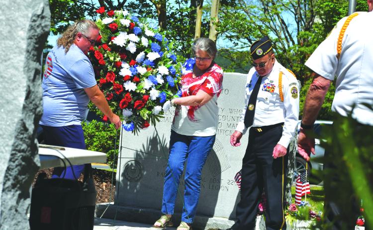 Megan Broome/The Clayton Tribune. Pam Wheeler, founder of the organization Creating Ties That Bind: For Soldiers and Families Wounded By Loss; and Karen Trombley, state coordinator for Quilts of Valor Foundation, place the wreath to honor soldiers who passed at the Memorial Day Ceremony held at the Rabun County Courthouse Monday. Also pictured are Chaplain Dr. Kenneth Franklin, DAV. CH. 15 and SVCDR. DAV. Ch. 15 Doug Wayne in the foreground.
