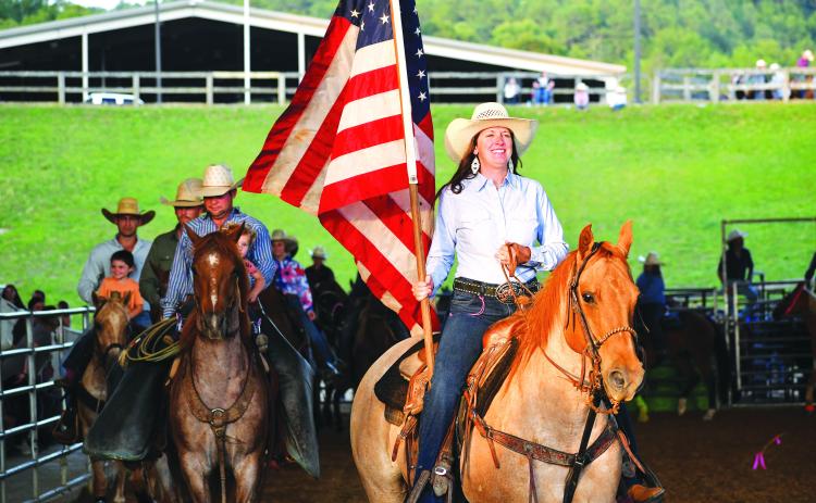 Luke Morey/The Clayton Tribune. Bar W Rodeo Company started the night with a procession led by the American Flag. 