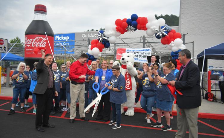 Megan Broome/The Clayton Tribune. Forward Rabun/Rabun County Chamber of Commerce celebrates with community members as they cut the ribbon on the newly renovated Walmart Supercenter in Clayton. 