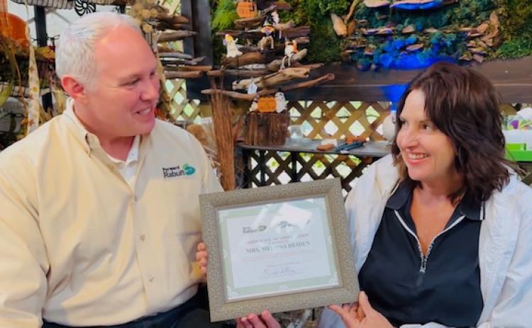 Photo courtesy Forward Rabun/Rabun County Chamber of Commerce. Rick Story, president of Forward Rabun/Rabun County Chamber of Commerce, presents Melissa Heiden with a Certificate of Appreciation for hosting one of the year’s best Open House Events. Left: Those in attendance at the open house event bought some of the beautiful garden items at the Lakemont garden business.