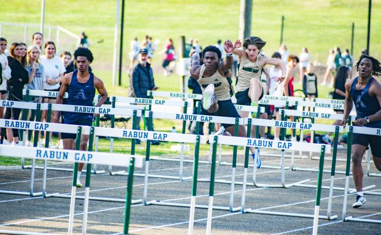 Wade Cheek/The Clayton Tribune. RGNS track and field hurdler Josh Buckhalter strides over a barrier to win the boys 110 meter hurdles during Rabun Gap’s home meet last Wednesday, March 20. 